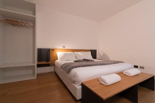 a bedroom with a large bed and a wooden table at La Villa - Luxury Guest House in Trento