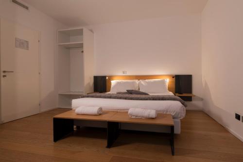 a bedroom with a large bed and a wooden table at La Villa - Luxury Guest House in Trento