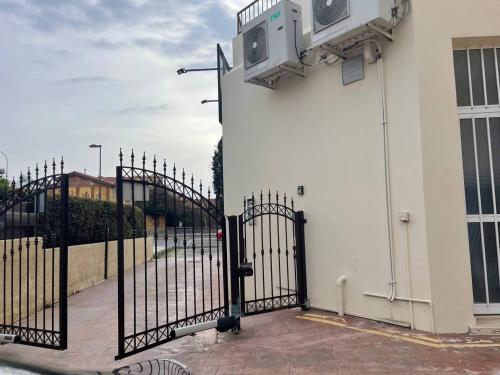 a white building with a black gate and a building at Queens gardens in Paphos