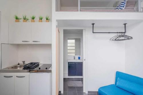 une cuisine avec des placards blancs et un canapé bleu dans l'établissement Authentic studio - 2P - Gare de l'Est, à Paris