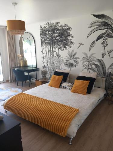 une chambre avec un grand lit avec des oreillers orange dans l'établissement Villa Victoria, à Marennes