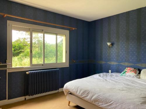 a bedroom with blue walls and a bed and a window at 5 Chambres dans une grande maison in Auneau