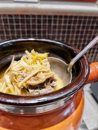 a pot of soup with noodles and a spoon at City Hotel Xiamen-Free Welcome Fruits in Xiamen
