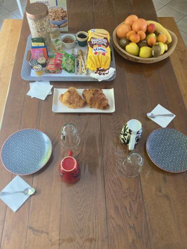 - une table avec une assiette de nourriture et un bol de fruits dans l'établissement Chez Suzanne, à Écouen