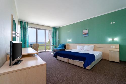 a hotel room with a bed and a television at MPM Hotel Arsena - Ultra All Inclusive in Nesebar