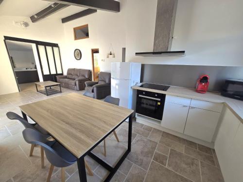 Il dispose d'une cuisine et d'un salon avec une table et des chaises en bois. dans l'établissement Evasion de charme, à Saint-Marcel-dʼArdèche