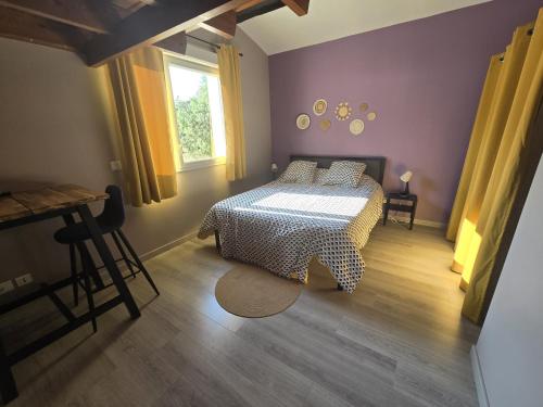 une chambre avec un lit, une table et une fenêtre dans l'établissement Evasion de charme, à Saint-Marcel-dʼArdèche
