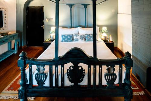 a bedroom with a four poster bed with white sheets at The Temi Bungalow South Sikkim in Namchi