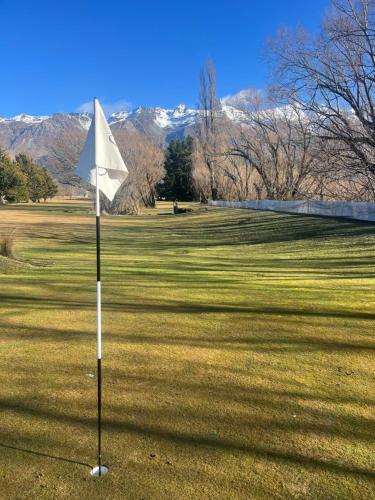 a white flag in the middle of a golf course at #2 Glenorchy Alpine Suite in Glenorchy