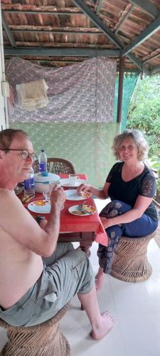 a man and a woman sitting at a table at Munroe Heritage Inn in Munroe Island