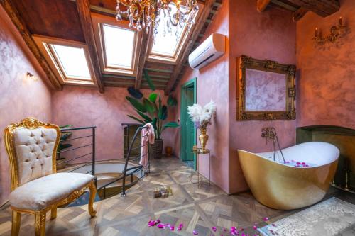 a bathroom with a tub and a chair in it at Casa Bonaparte in Pula