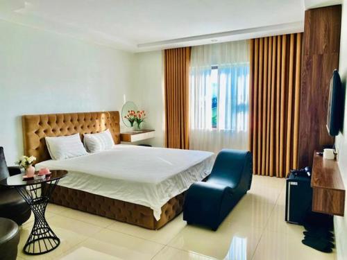 a bedroom with a large bed and a blue chair at Ruby Hotel - Gần Trung tâm khảo thí ĐHTN in Thái Nguyên