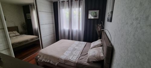 a small bedroom with a bed and a mirror at Villa accueillante entre Aix et Marseille in Vitrolles