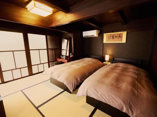 a bedroom with two beds in a room at 以久波別邸虎屋 in Ukiha