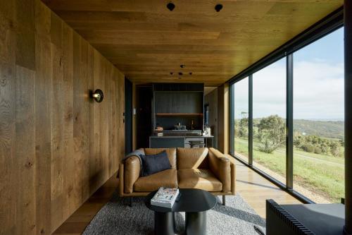 a living room with a couch and large windows at Nest & Nature in Inman Valley