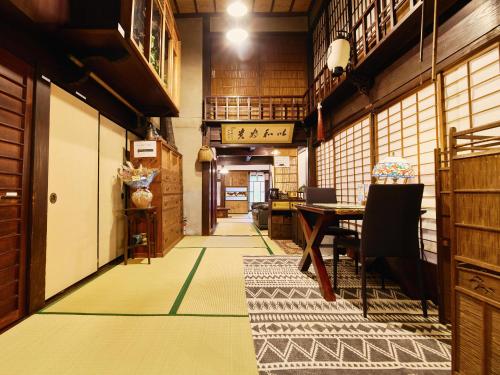a hallway with a table and chairs in a room at 以久波別邸虎屋 in Ukiha