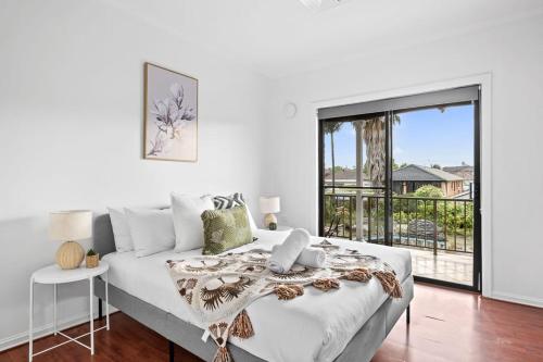 a white bedroom with a bed and a balcony at Cozy Private Double Room - Near Stations & Shops - Shared Bathroom in Bankstown