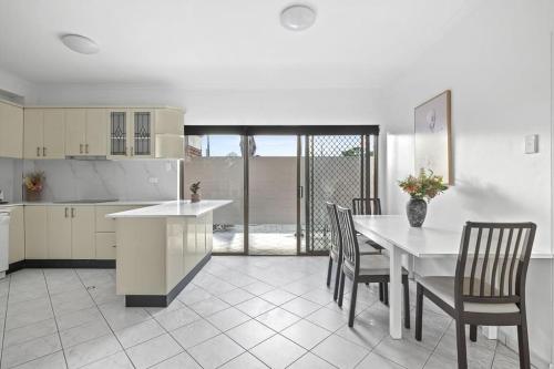 a kitchen and dining room with a table and chairs at Cozy Private Double Room - Near Stations & Shops - Shared Bathroom in Bankstown