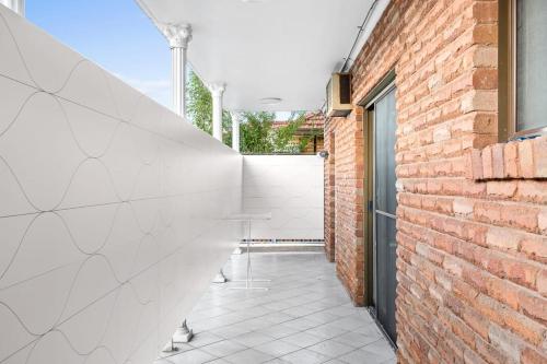 a hallway with a brick wall and a door at Cozy Private Double Room - Near Stations & Shops - Shared Bathroom in Bankstown