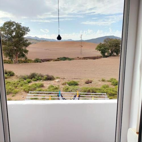 a window with a view of an open field at un bel appartement de vacances au calme in M'diq