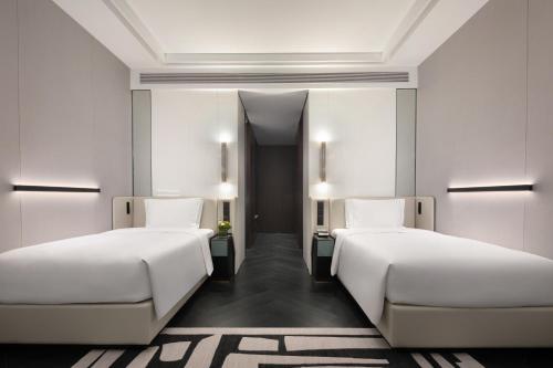 two beds in a room with white walls at Crowne Plaza Suzhou East Taihu by IHG in Suzhou
