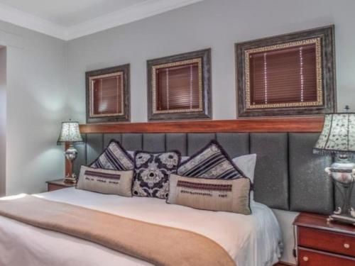 a bedroom with a white bed with two windows at Fairview Manor in Modimolle