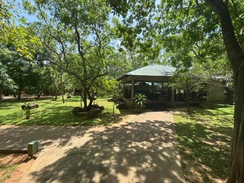 a pavilion in the middle of a park with trees at Hotel Elephant Reach in Yala