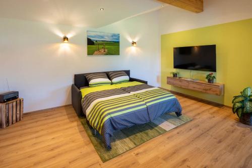 Un dormitorio con una cama y un televisor de pantalla plana. en Ferienwohnung Egg-Hof, en Bad Grönenbach
