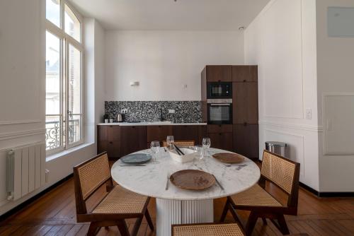 une cuisine avec une table et des chaises et une cuisine avec une fenêtre dans l'établissement Reims Cathédrale Hyper Centre, à Reims