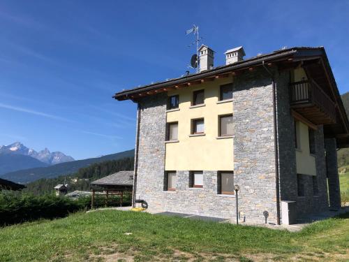 a building on a hill with mountains in the background at Le Bouvier in Doues