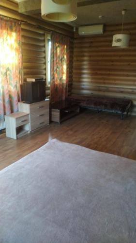 a living room with a couch and a flat screen tv at Pastoral wooden hauses in Velikiy Les