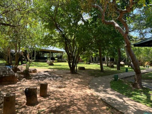 a park with trees and a path and a building at Hotel Elephant Reach in Yala