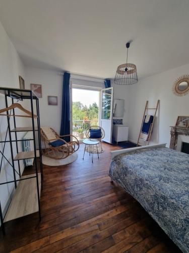 a bedroom with a bed and a table and chairs at La Maison du Mont in Graignes
