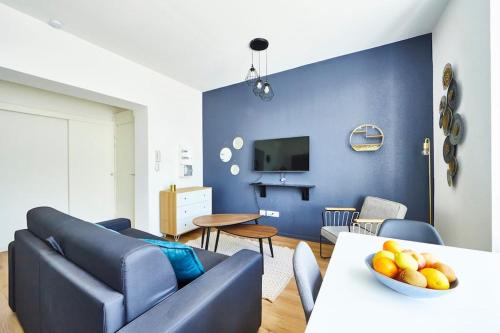 un salon bleu avec un canapé et une table dans l'établissement BM-0 Appartement chaleureux F2 au RDC à Mulhouse - 1 à 4 pers, à Mulhouse