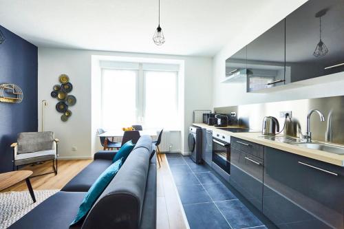 un salon avec un canapé et une cuisine dans l'établissement BM-0 Appartement chaleureux F2 au RDC à Mulhouse - 1 à 4 pers, à Mulhouse