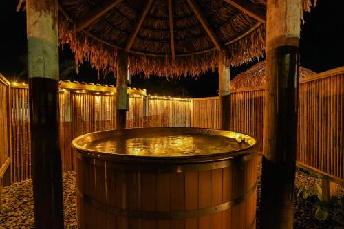 a large wooden tub with an umbrella in a room at Tasman Holiday Parks - Beachaven in Waihi Beach