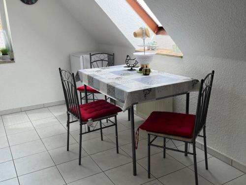 a dining room table with four chairs and a table with a lamp at Sunny Loft with Mountain Views in Elbingerode