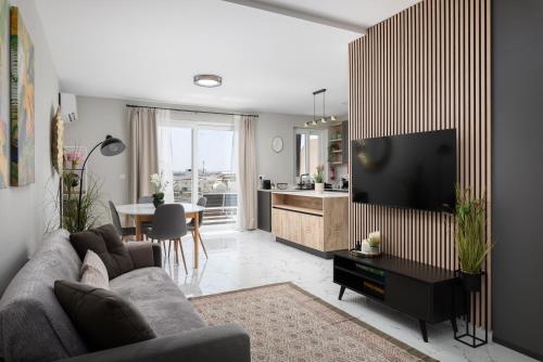 a living room with a couch and a flat screen tv at Modern 2BR Cosy Apartment with Large Terrace - Close to Manoel Island & Tigne Shopping Mall in Sliema