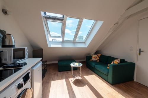 - un salon mansardé avec un canapé vert dans l'établissement Hyper Centre Cathédrale Langlet, à Reims