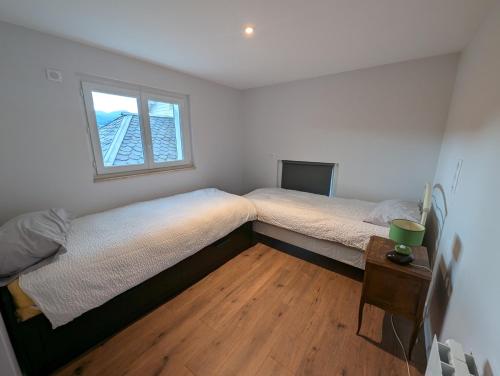 two twin beds in a bedroom with a window at Logis Hôtel Le Beau Site in Chambon-sur-Lac