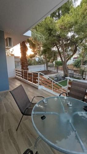 a glass table and chairs in a room with a tree at House with a pool, 2' from the beach in Kineta