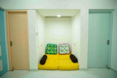 two chairs sitting on a yellow couch in a room at Cayzen in Chennai