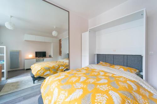 une chambre avec deux lits et un grand miroir dans l'établissement Miroir en Lumière - Studio à 10min du 13e Paris, à Ivry-sur-Seine