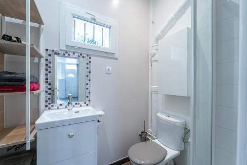une salle de bain blanche avec des toilettes et un lavabo dans l'établissement Miroir en Lumière - Studio à 10min du 13e Paris, à Ivry-sur-Seine
