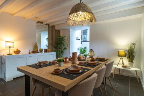 une table à manger avec des chaises et un lustre dans l'établissement La Loc'Oyarn - Maison avec parking privé, à Hennebont