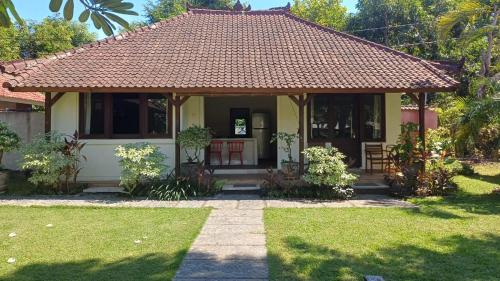 The Beach Bungalows & Turtle Sanctuary في بيموتيران: منزل أصفر صغير بسقف من البلاط