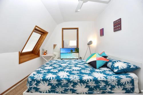 ティー・ガーデンズにあるTea Garden Waterfront Blissのベッドルーム1室(ノートパソコン付きのベッド1台付)