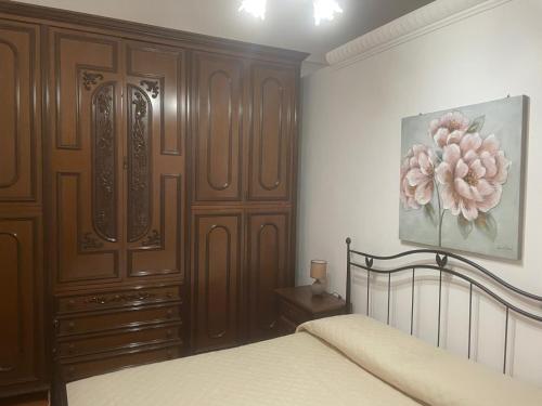 una camera da letto con un letto e un grande armadio in legno di Casa Noto Fiorita a Noto