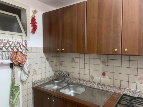 una cucina con lavello e mobili in legno di Casa Noto Fiorita a Noto