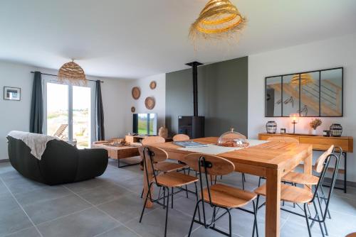 un salon avec une table et des chaises en bois dans l'établissement Ty Penecam - Parking privé à 2km de la plage, au Palais